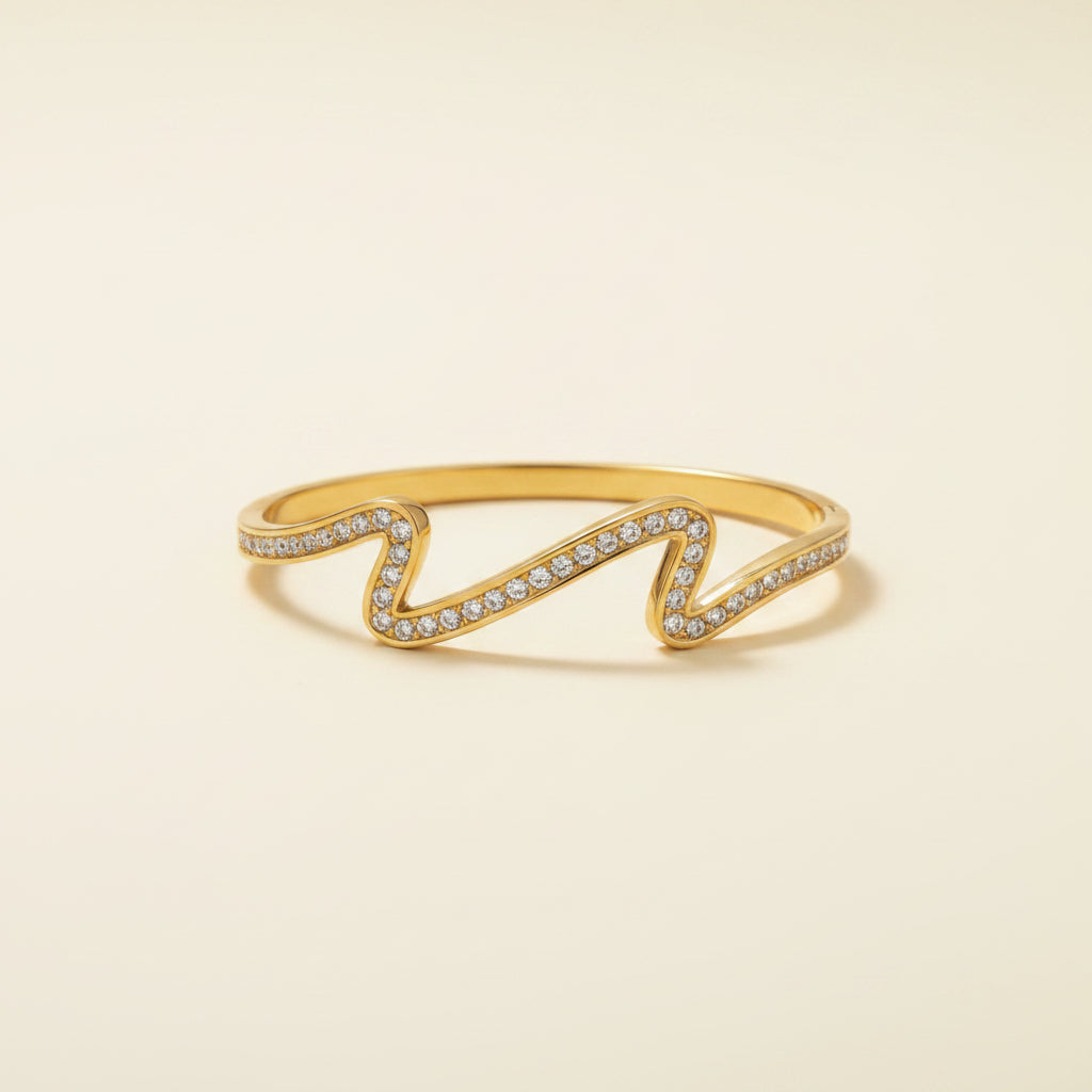 Detailed shot of the high-quality 18K gold plating and the secure hidden side-lock of the Aurielle Crystal Wave Bangle.
