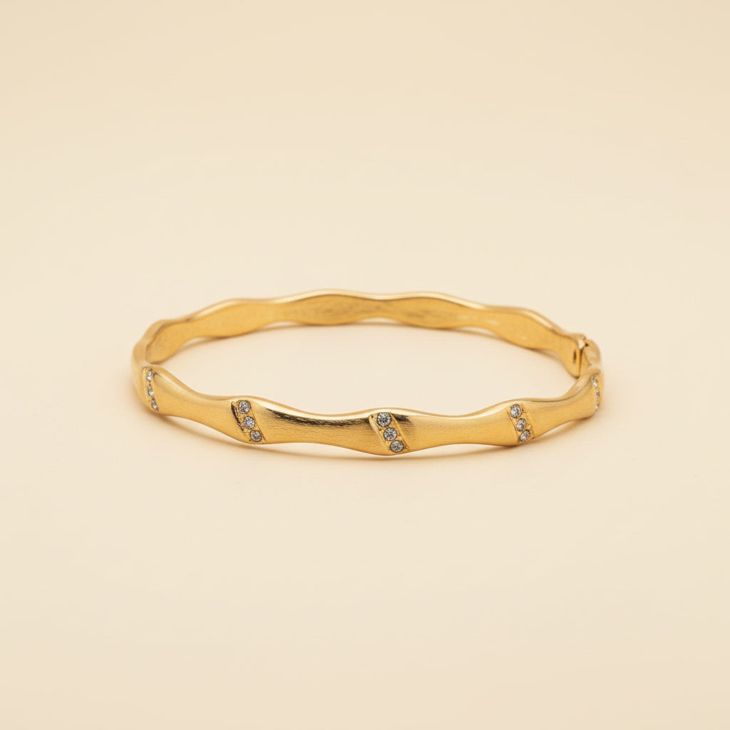 Detailed shot of the secure hidden lock mechanism and the premium anti-tarnish plating of the fluid gold bangle.
