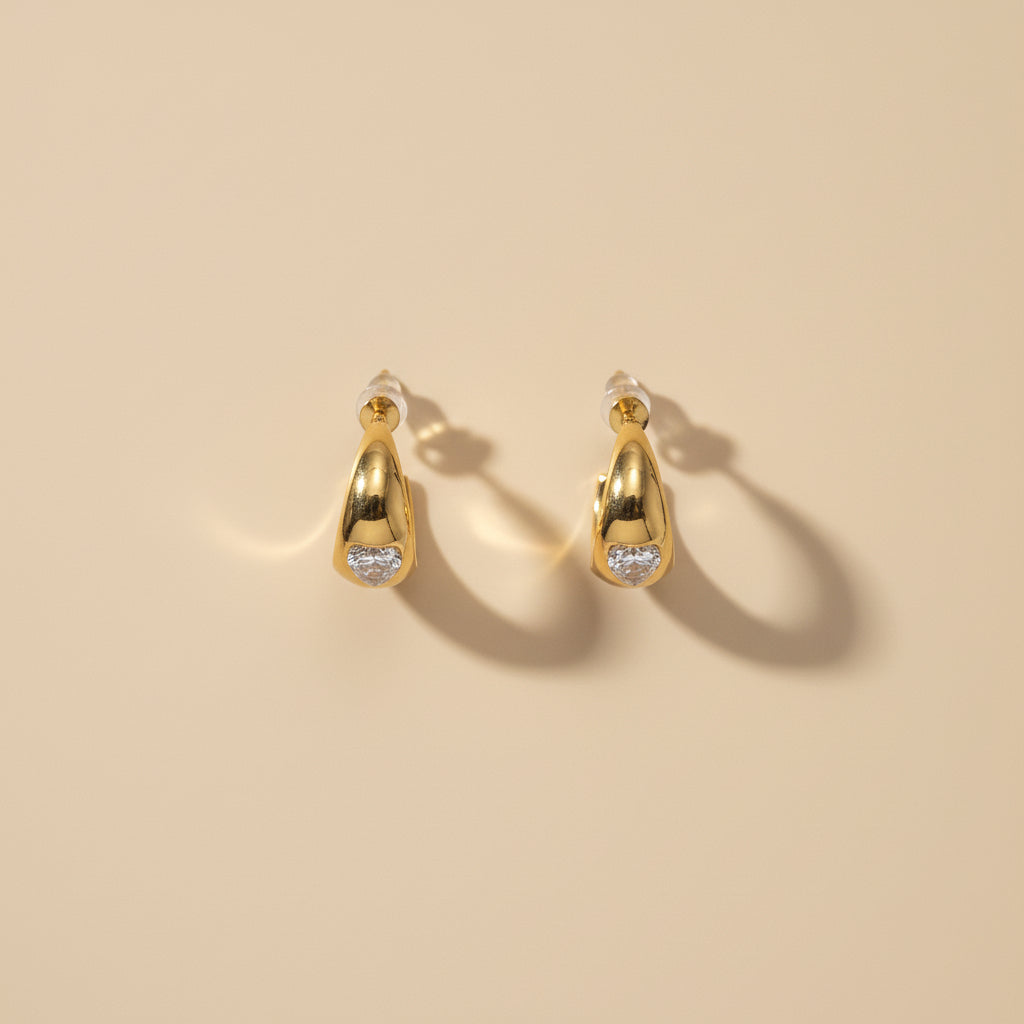 Detailed shot of the high-quality gold plating and secure push-back closure of the heart stud earrings.