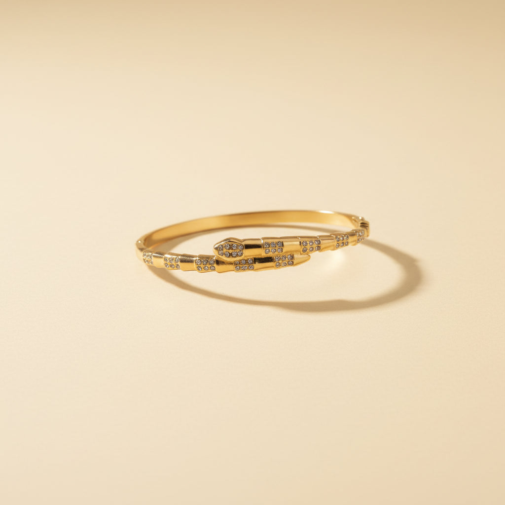 Close-up shot of the high-quality gold plating and minimalist scale detailing on the serpent wrap bangle.