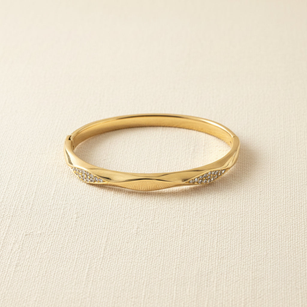 Detailed shot of the high-quality 18K gold plating and the secure integrated side-lock of the twisted crystal bangle.