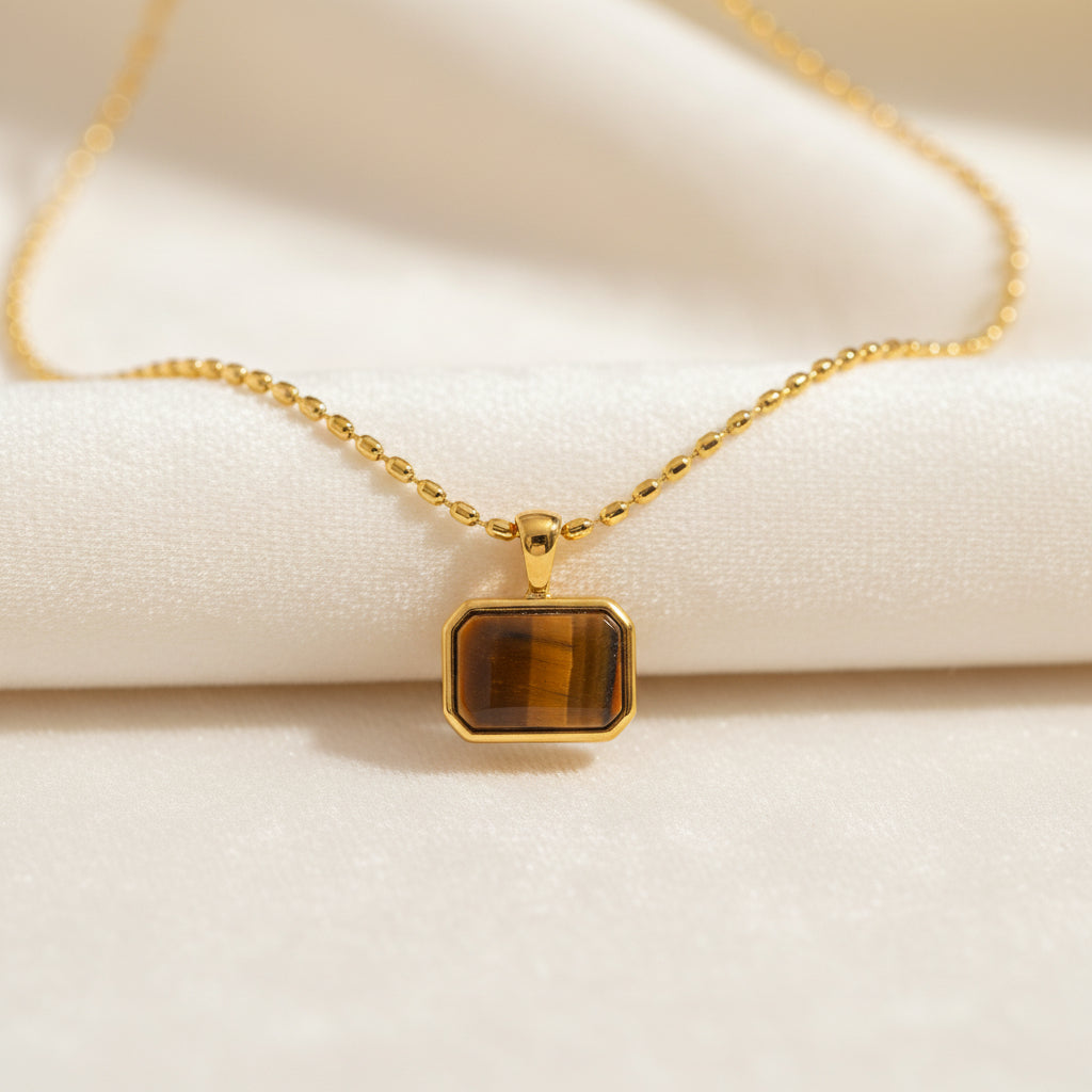Close-up of a gold Tiger Eye pendant necklace showing natural stone details.