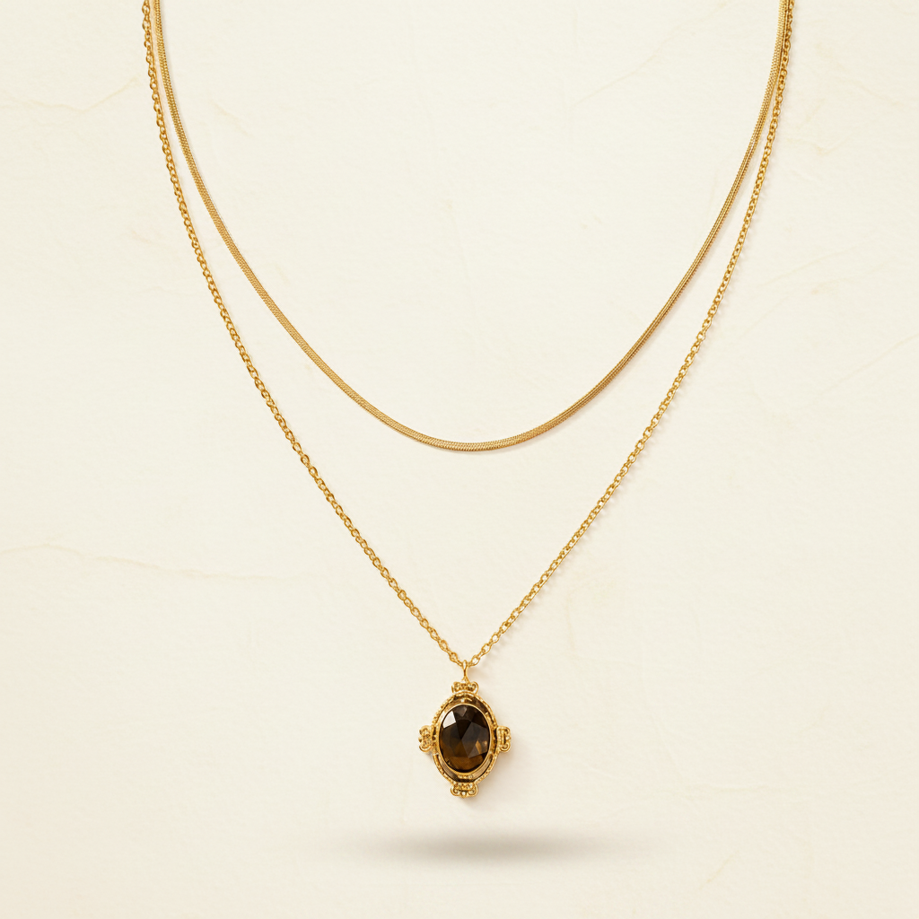 Layered gold necklace with pendant displayed on a #f5f3eb luxury catalogue background.