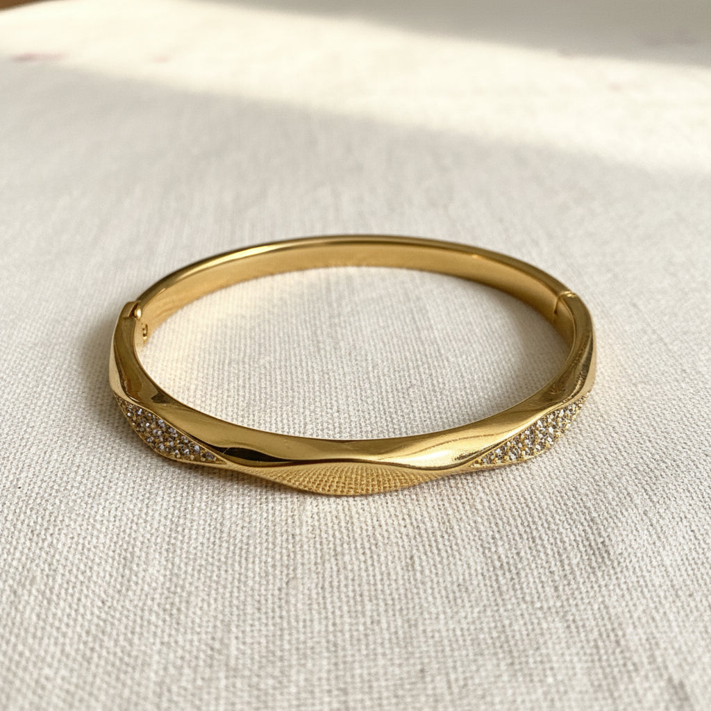 A close-up view of the Celestia Twist Crystal Bangle highlighting the interlocking gold and crystal bands.