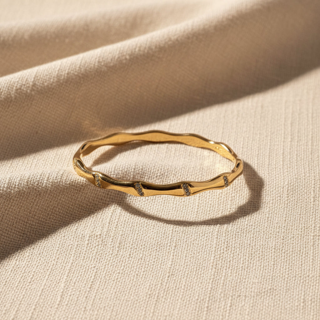 Gold bracelet on a textured gray surface