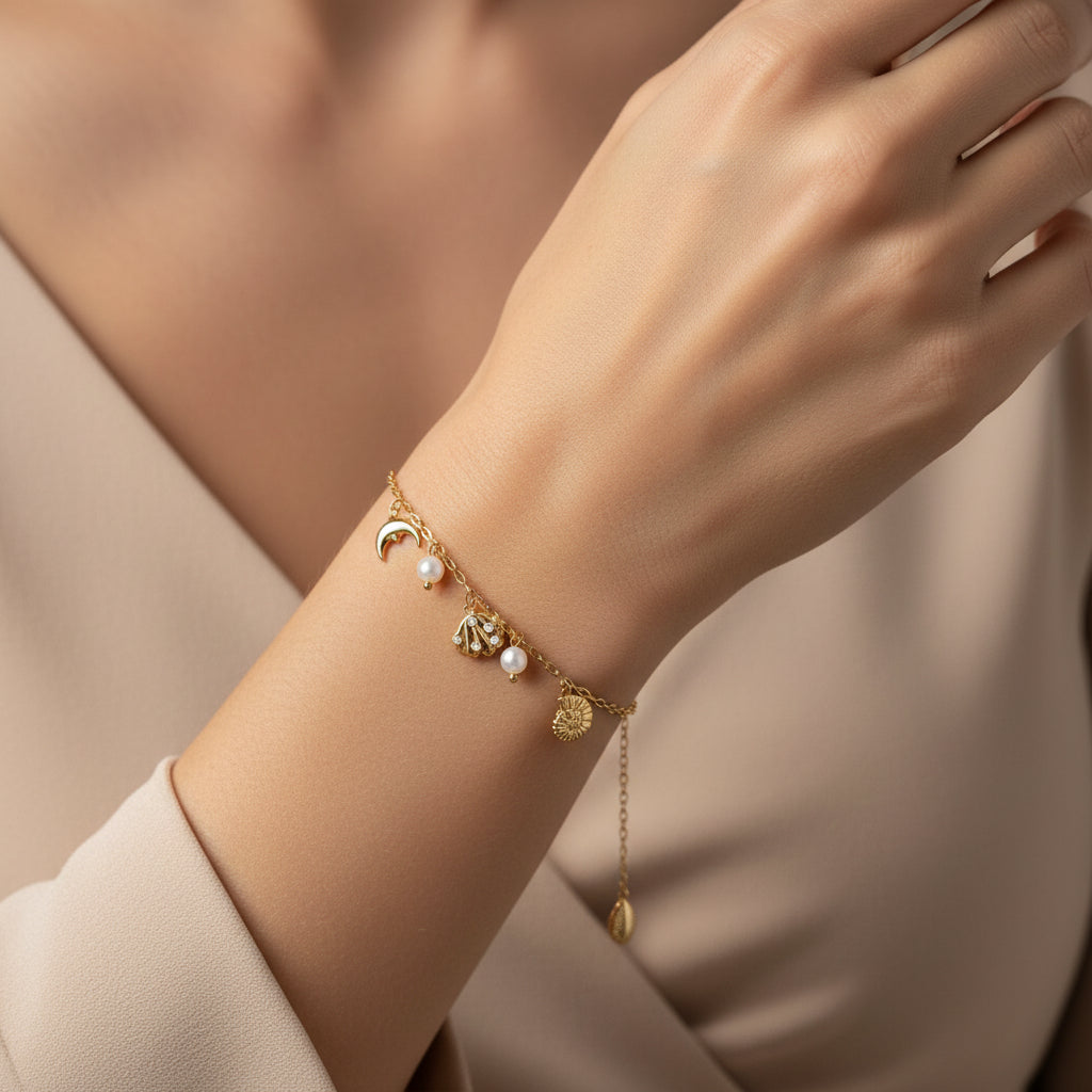 A model's wrist wearing the Ocean Charm Bracelet to show the charms in motion and the adjustable fit.