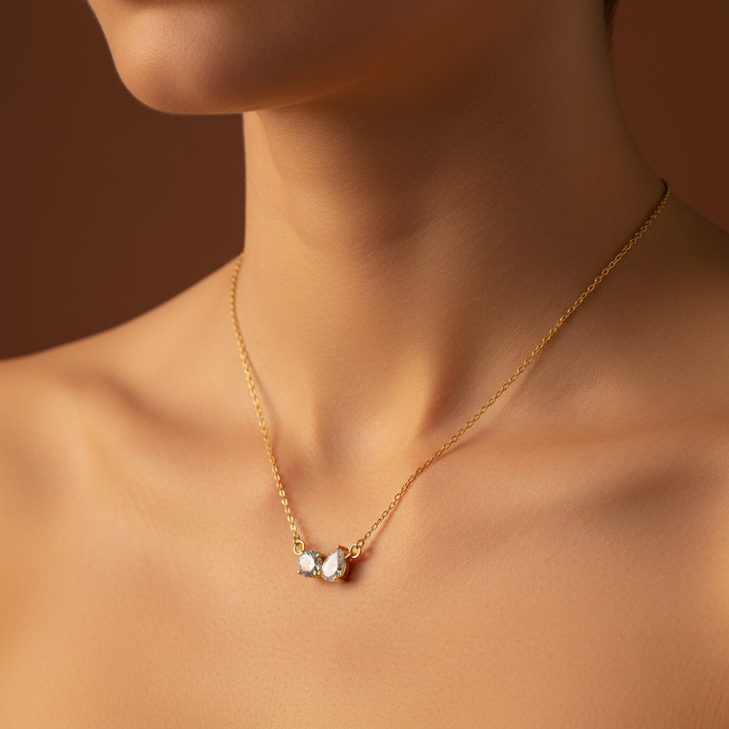 A detailed, realistic photograph focusing closely on a woman's neck, wearing the gold chain with round and teardrop crystal pendant under warm golden lighting against a rich #5b3b3a brown background.