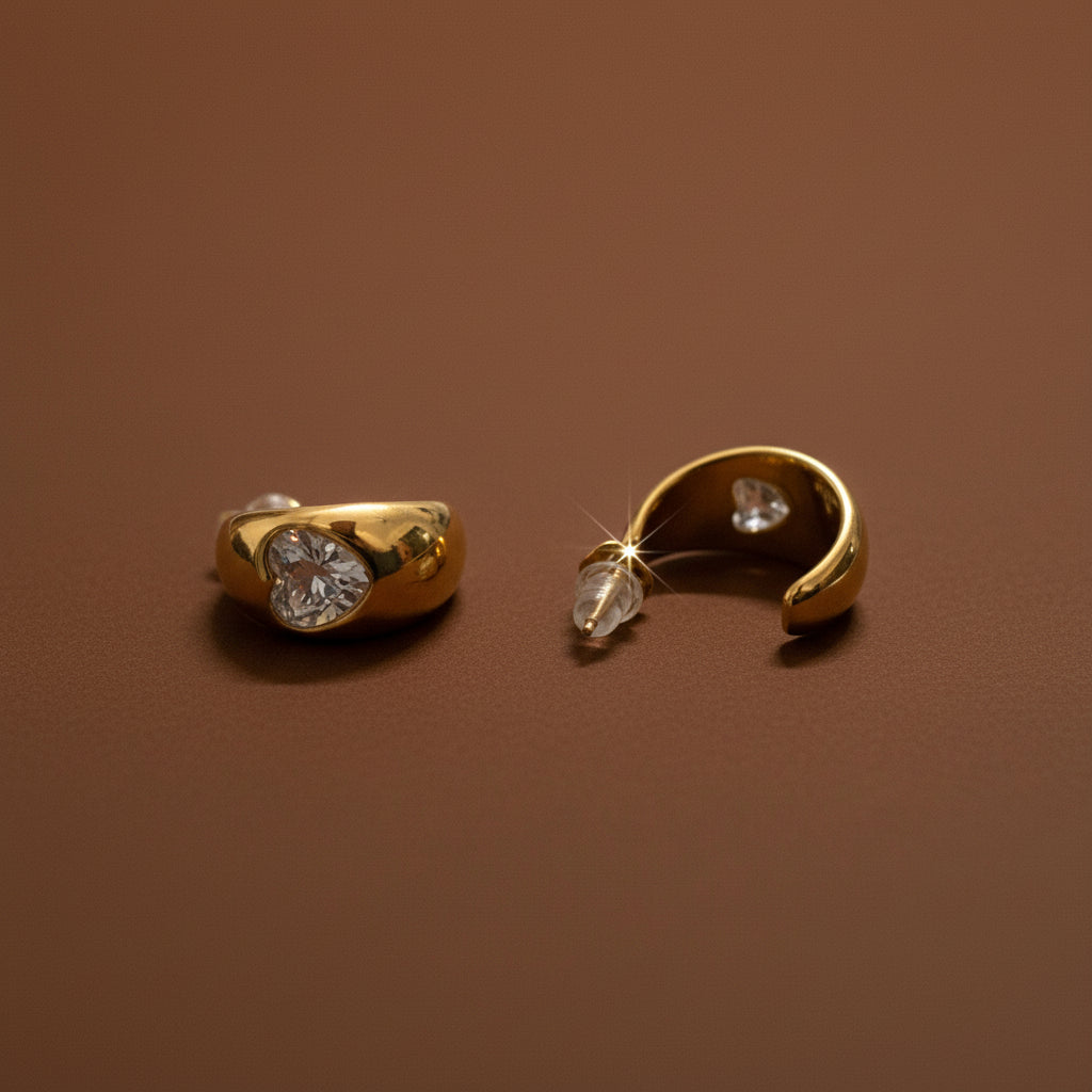 A front-facing close-up of the Golden Curve Heart Stud Earrings showcasing the polished 18K gold-plated finish.