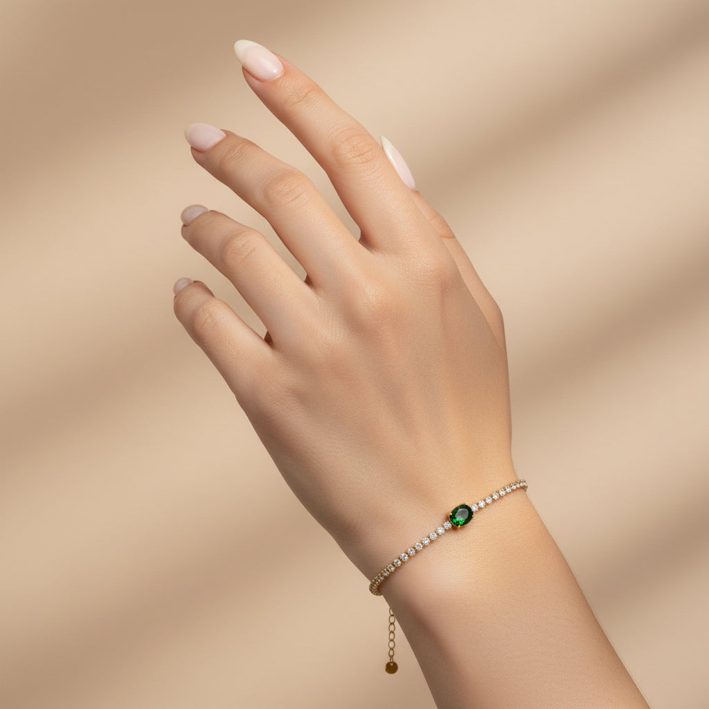 Bracelet with a green gemstone on a pink fabric background