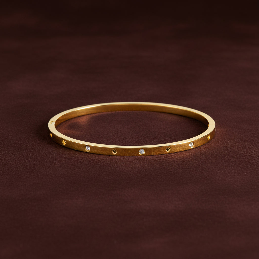A close-up view of the Luna Heart Radiant Bangle highlighting the brilliant heart-cut crystal and polished 18K gold finish.