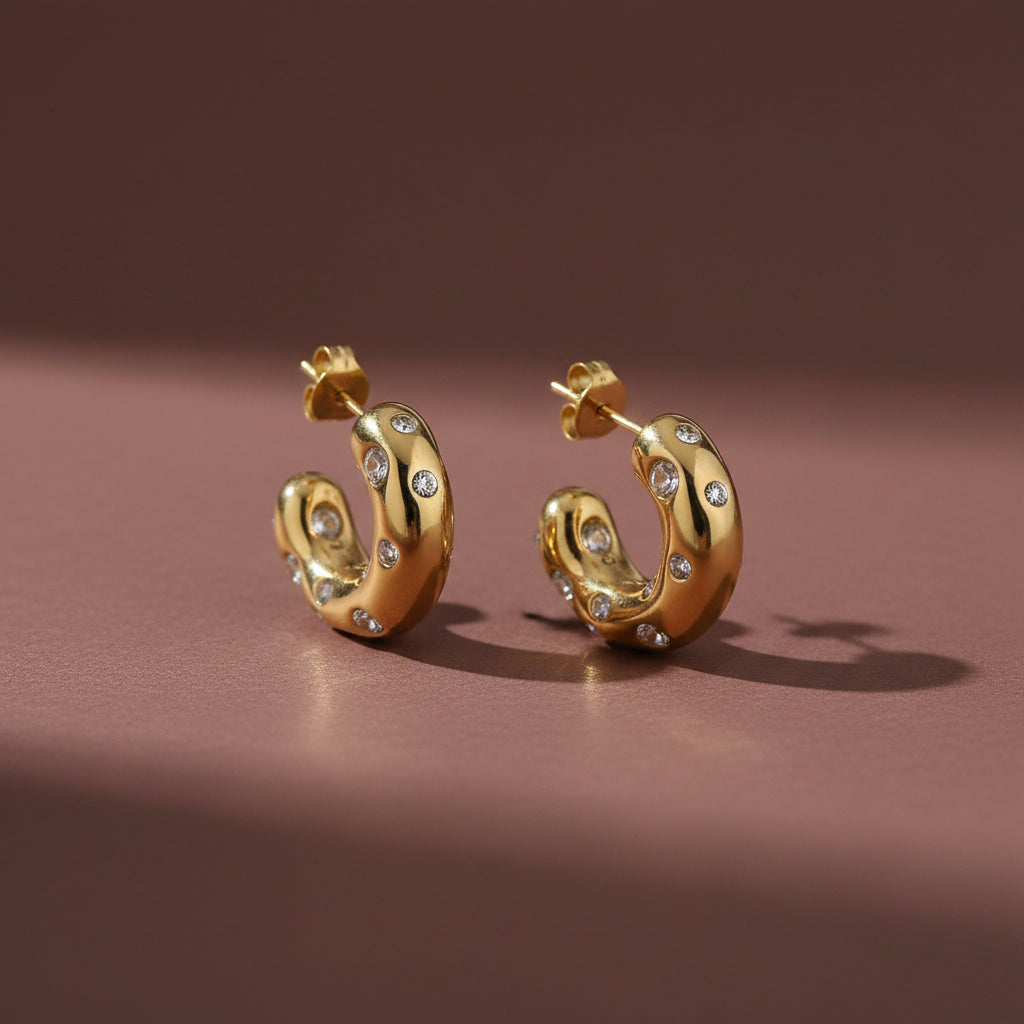 Nova Pavé Link Hoop Earrings with Cubic Zirconia on a luxury #5b3b3a catalogue background.