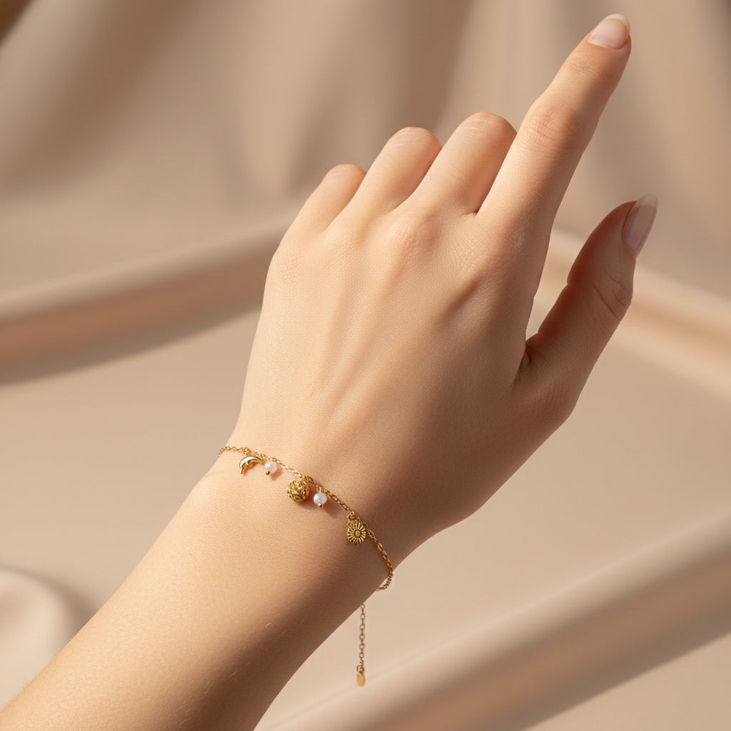 Gold bracelet with charms on a red textured surface