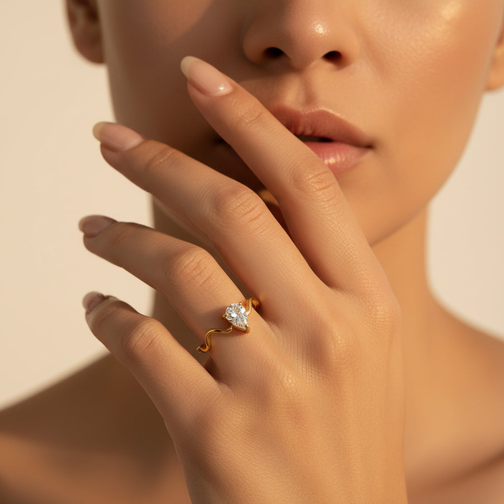 Serena Wave Pear Ring styled on cream linen with luxury jewellery box and elegant editorial accessories.