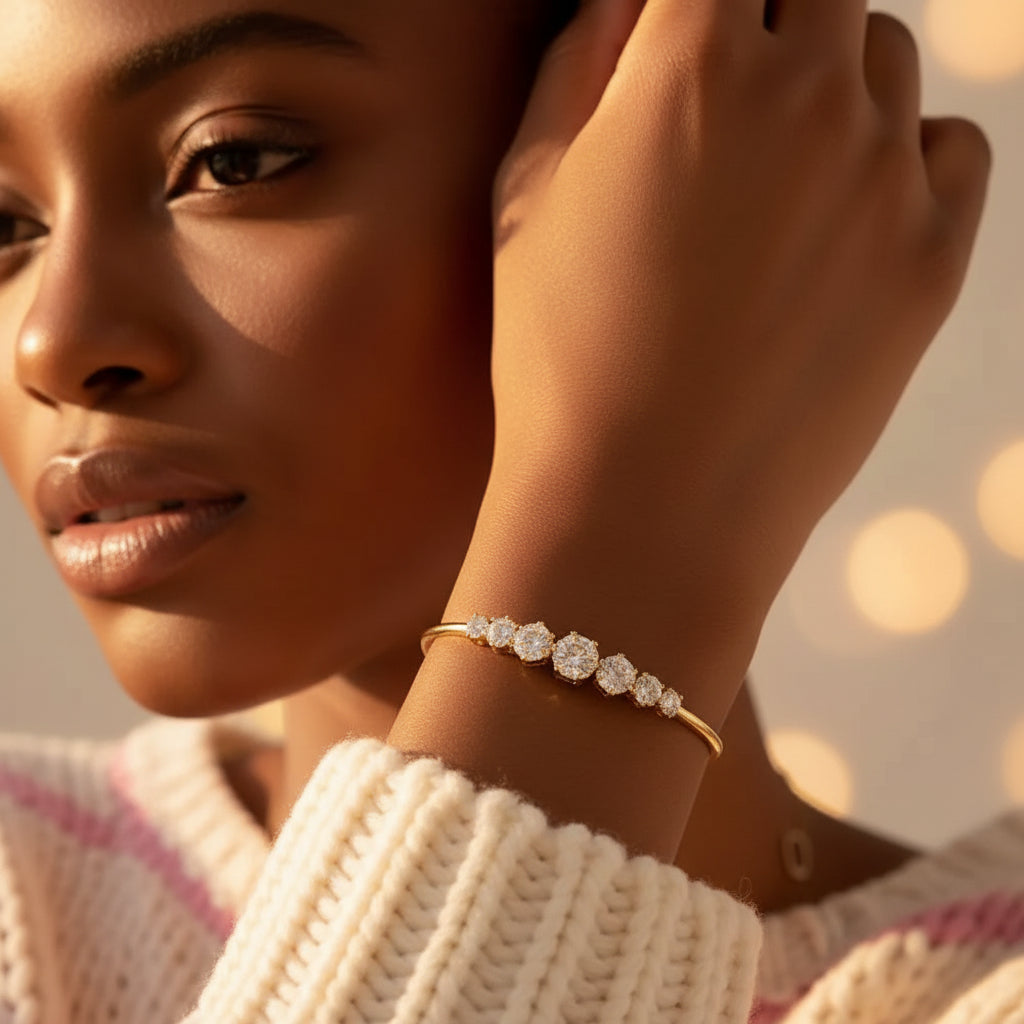 Realistic flat lay photograph of the premium gold graduated crystal open cuff Kada bracelet resting naturally on textured cream linen cloth.