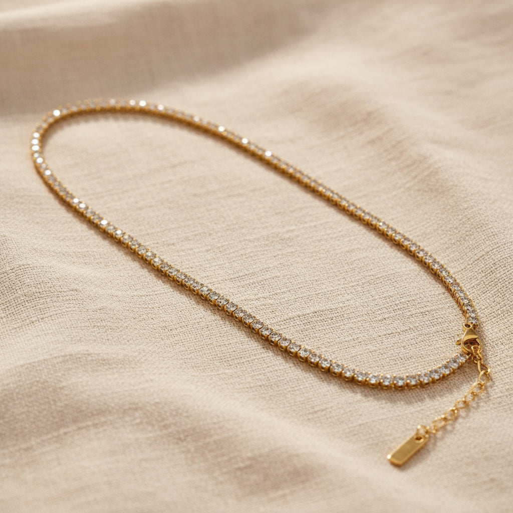 Detailed shot of the lobster clasp and the continuous stone setting of the gold tennis necklace.