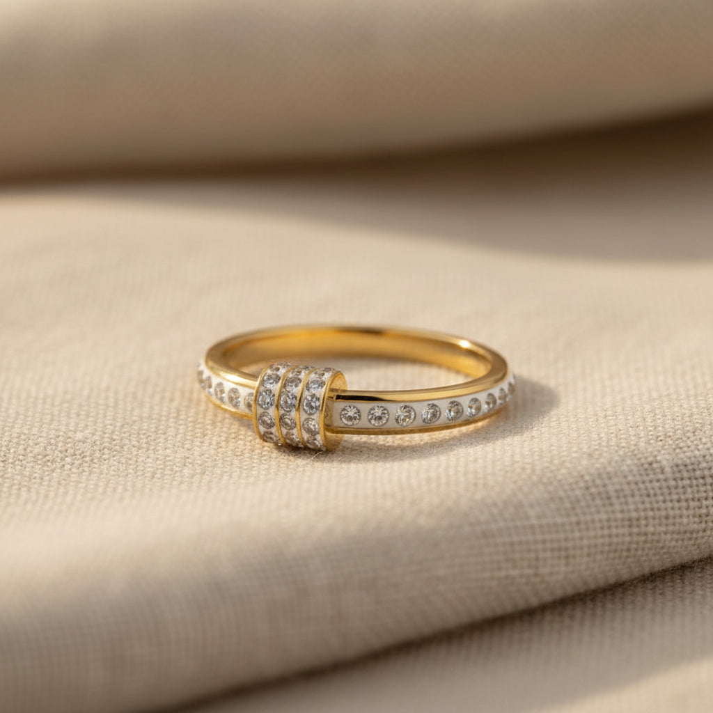 A realistic, natural daylight flat lay photograph of the premium gold white enamel crystal knot ring resting beautifully on a textured cream linen cloth.
