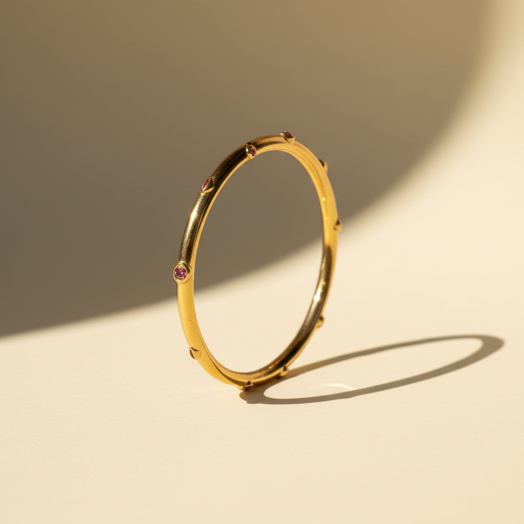 Detailed shot of the high-quality gold plating and the secure side-lock mechanism on the pink stone gold bangle.