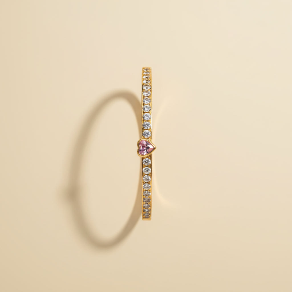 Detailed shot of the high-quality gold plating and the secure side-lock mechanism on the pink heart stone bangle.