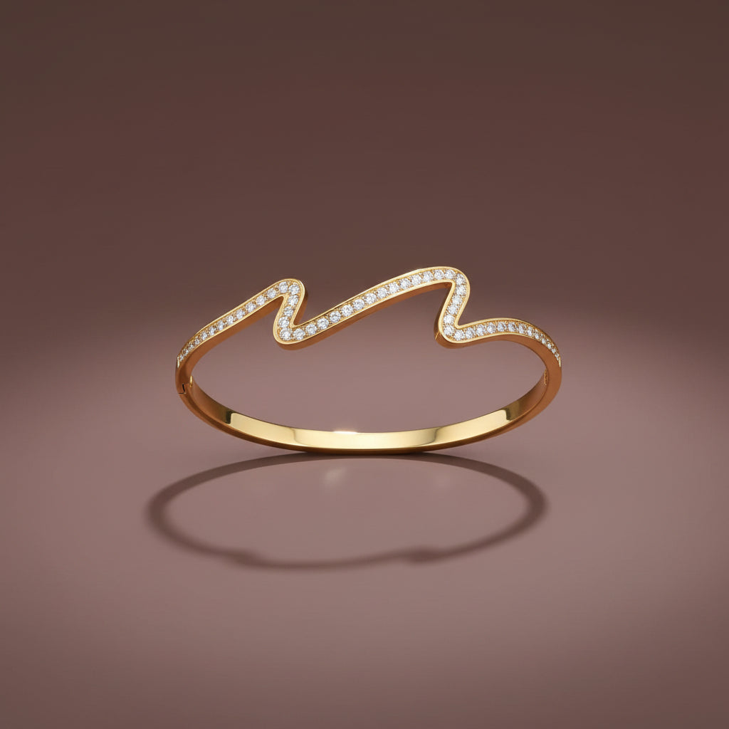 A high-resolution close-up of the Aurielle Crystal Wave Bangle highlighting the intertwining gold and crystal wave design.