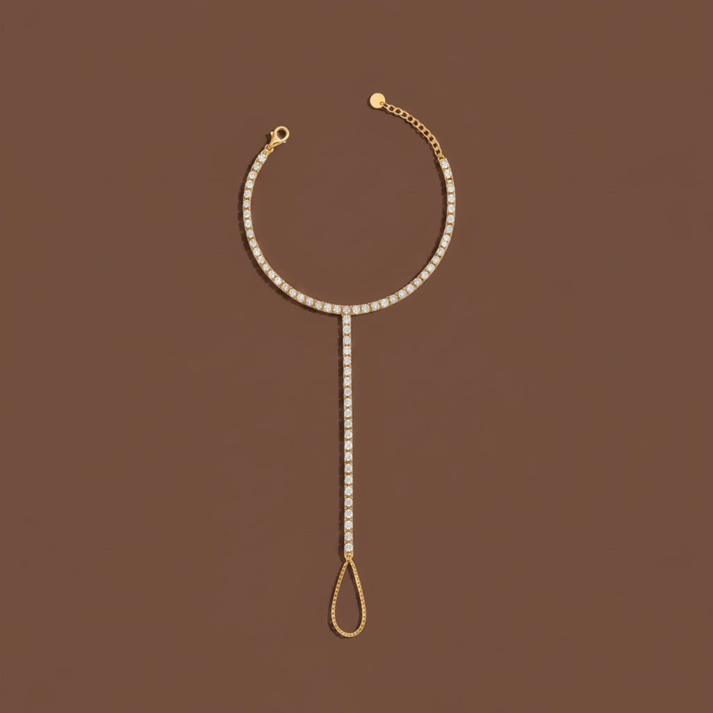 Gold tennis hand chain with cubic zirconia displayed in a floating luxury product shot.