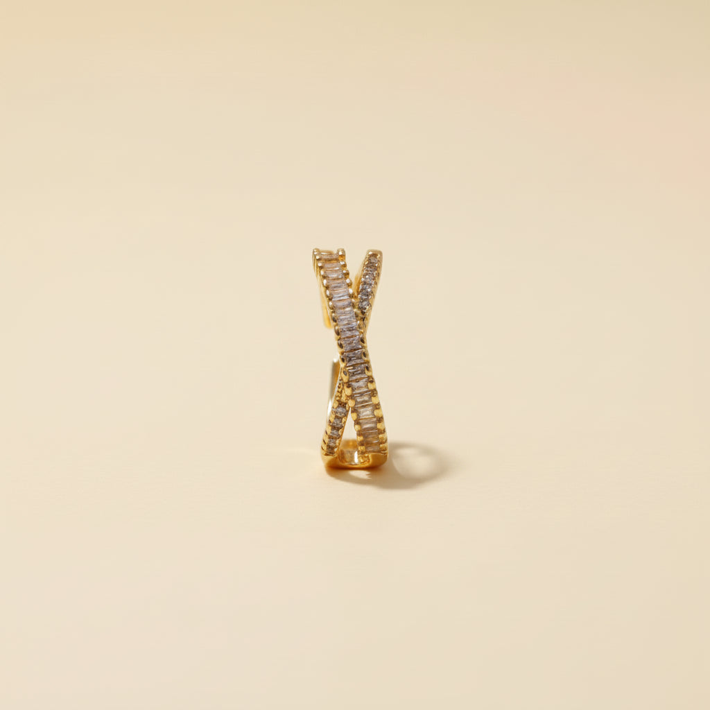 Adjustable gold criss-cross ring with Cubic Zirconia stones on a premium cream background