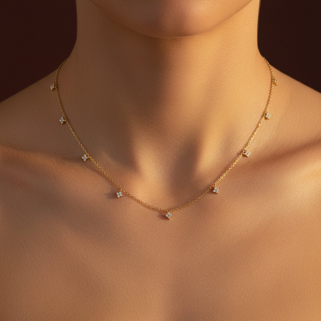 A close-up view of the Dainty Floral Charm Necklace showing the tiny crystal-studded flower charms and gold chain.