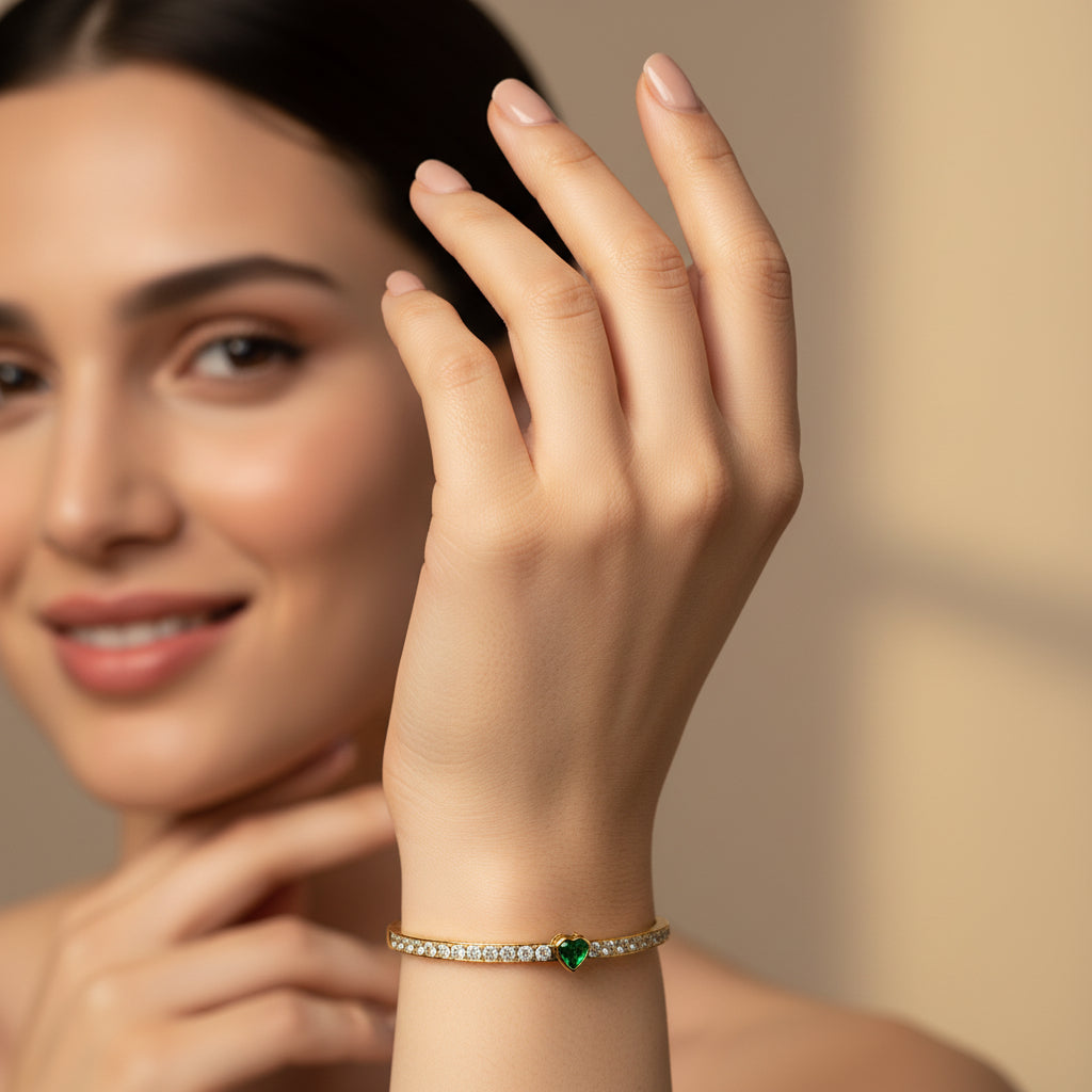 Gold bracelet with green gemstone on a white cushion