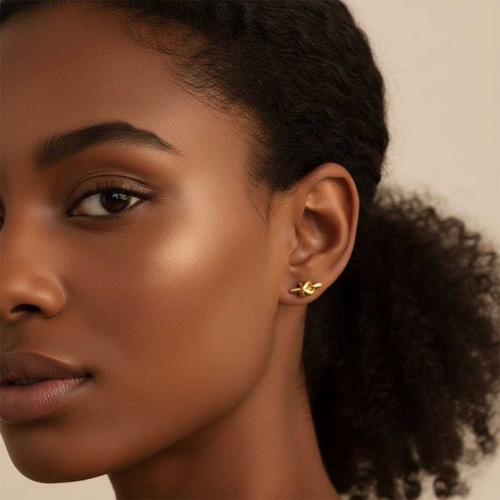 Black female model wearing Eterna Knot Stud Earrings in a luxury jewellery campaign.