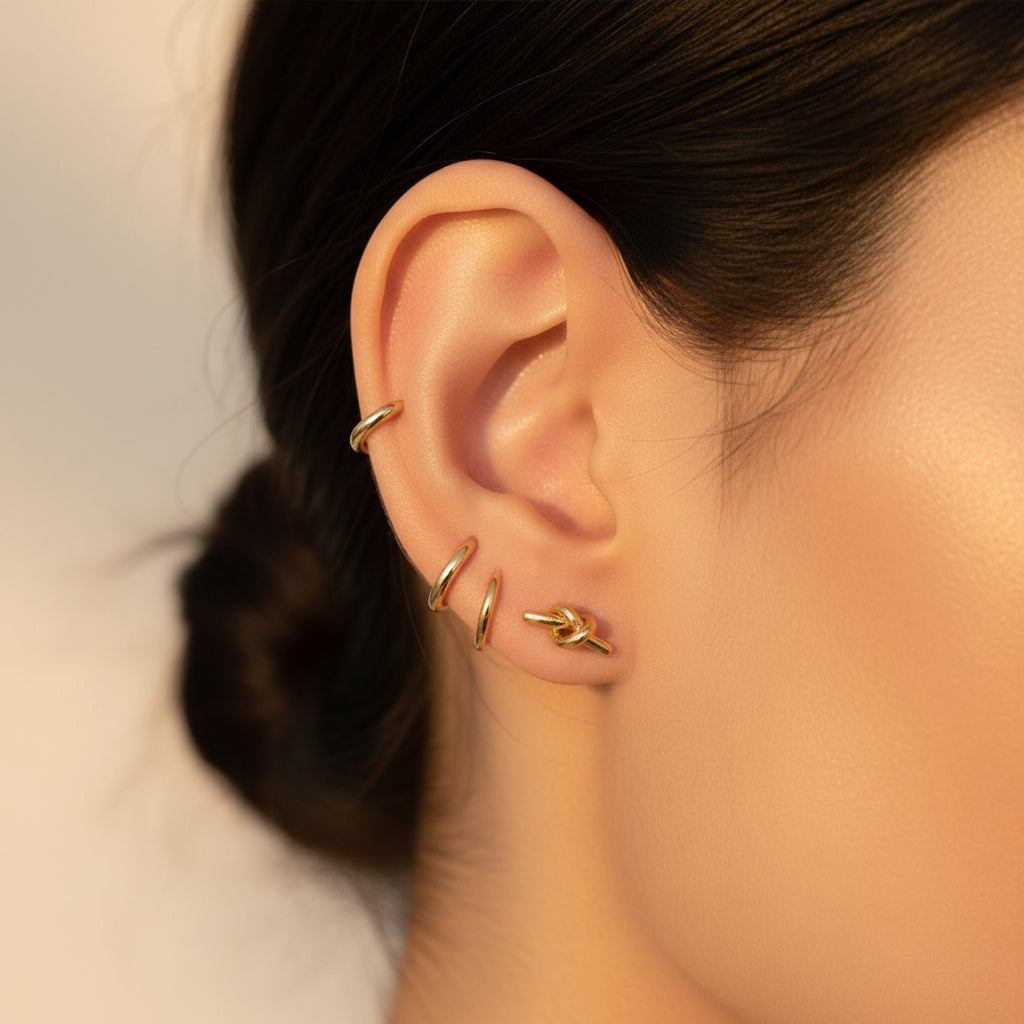 Eterna Knot Stud Earrings styled in a modern curated ear stack.