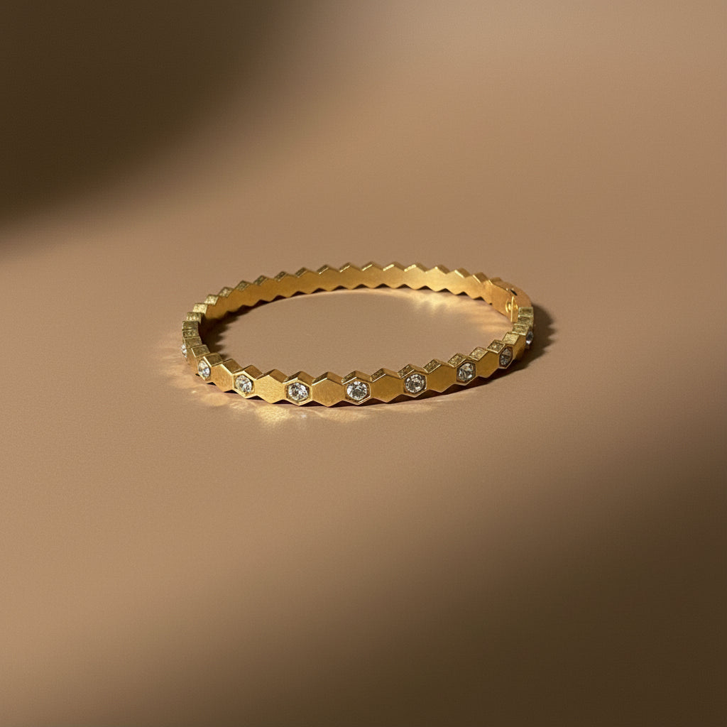 A close-up view of the Geometric Stone Gold Bangle highlighting the linear clear stone setting and high-shine 18K gold finish.