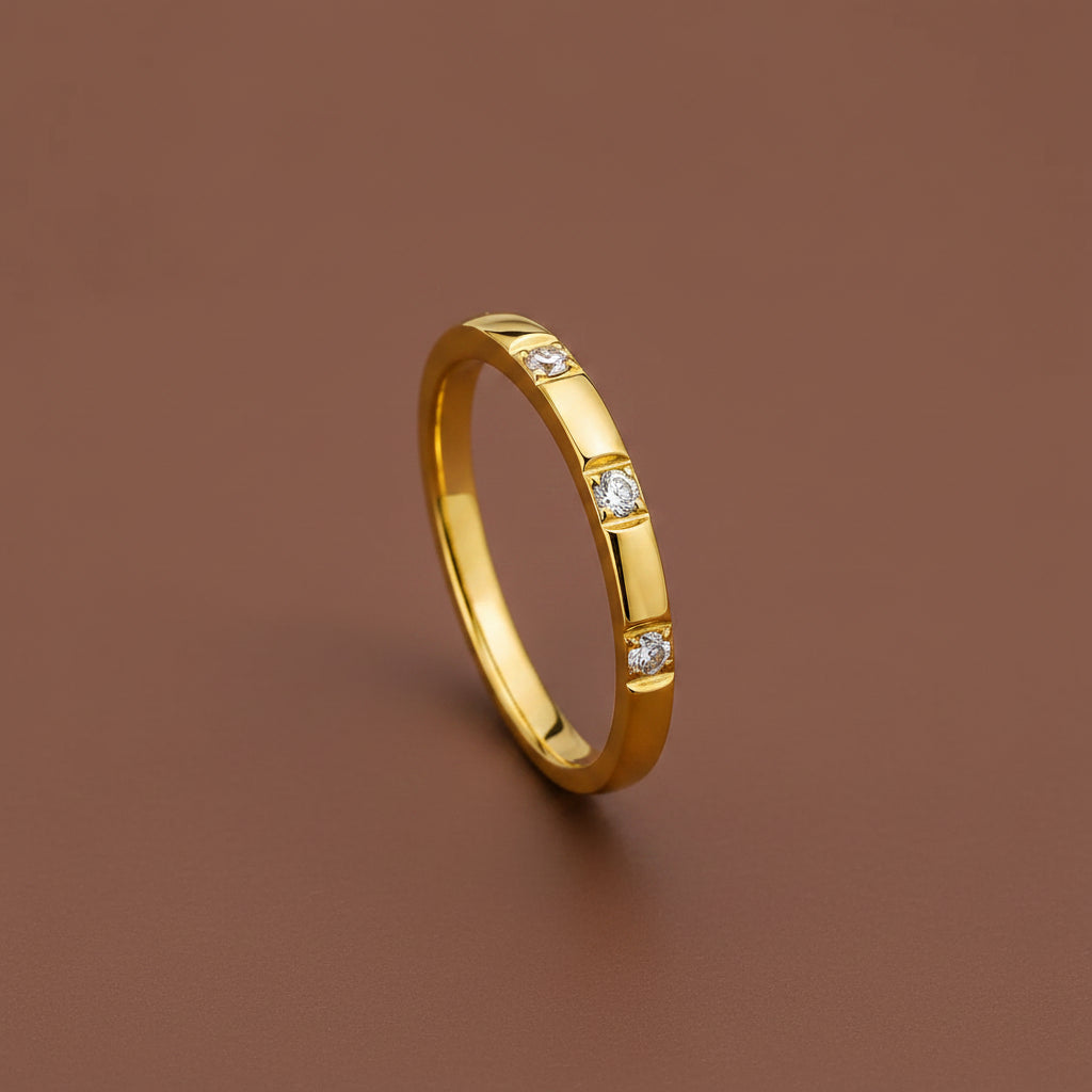 A professional high-angle flat lay catalogue shot of the gold plated minimalist triple stone flat-edge ring with flush square bezel settings, isolated on a rich #5b3b3a brown background