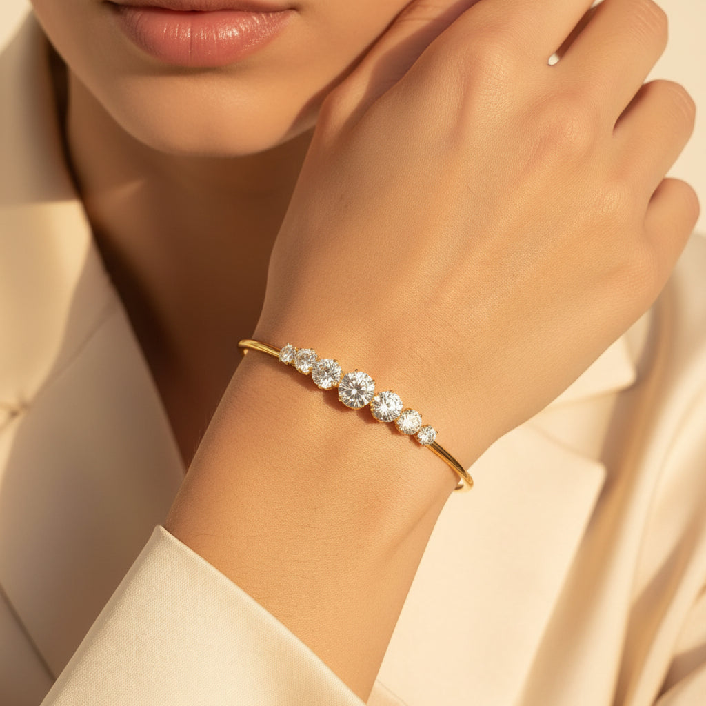Professional standing catalogue view of the 18K gold plated crystal-crowned open cuff bracelet on a minimal light cream background.