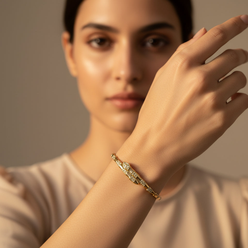 A model's wrist wearing the Serpent Gold Bangle to showcase its bold silhouette and high-end golden luster.