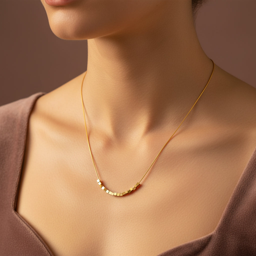 A close-up view of the Minimal Gold Cube Necklace highlighting the structured gold cubes and high-shine finish.