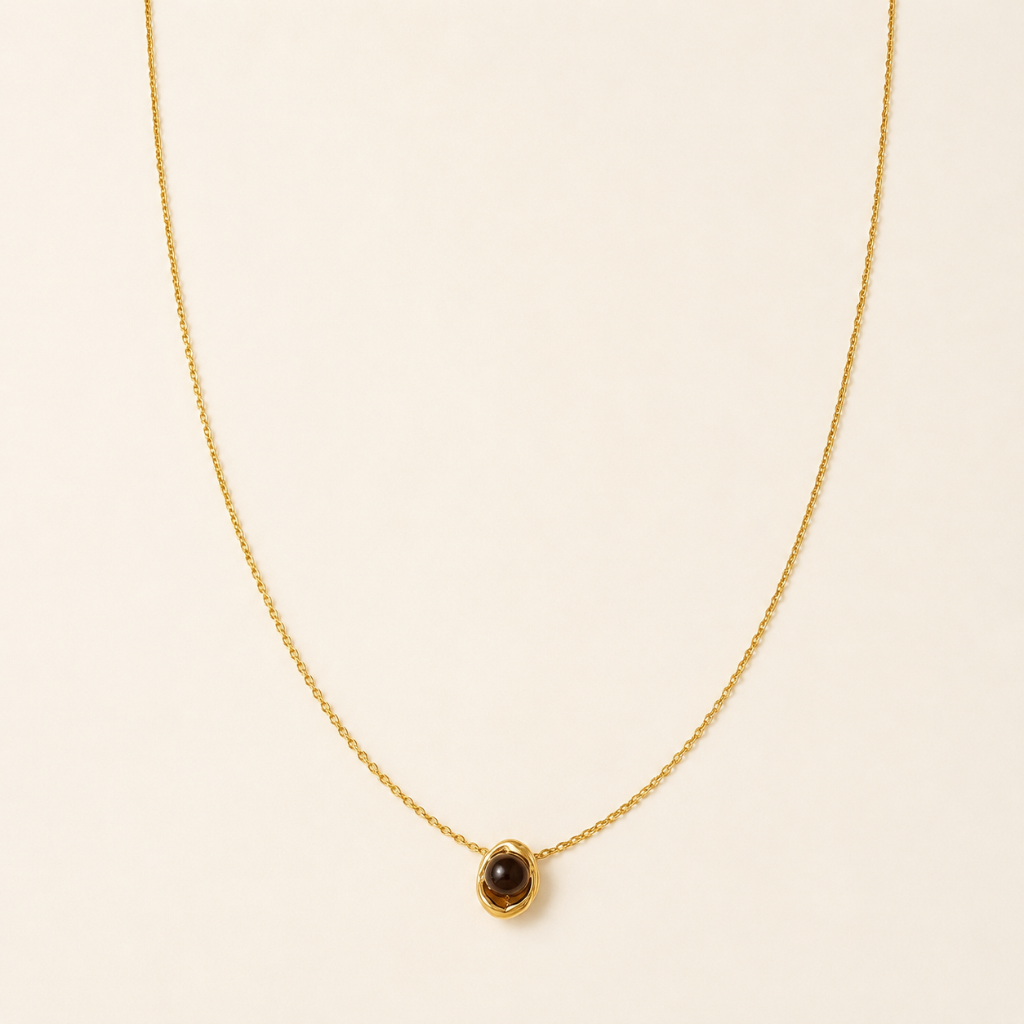 Elegant woman wearing a black stone pendant necklace.