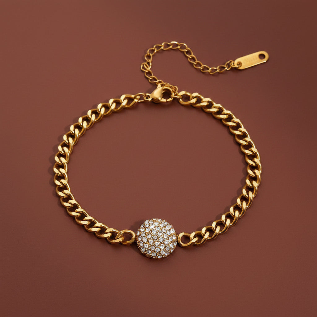 Professional catalogue flat lay of the 18K gold plated pavé crystal disc curb chain bracelet arranged in a precise circle with soft shadows on a deep cocoa brown background.