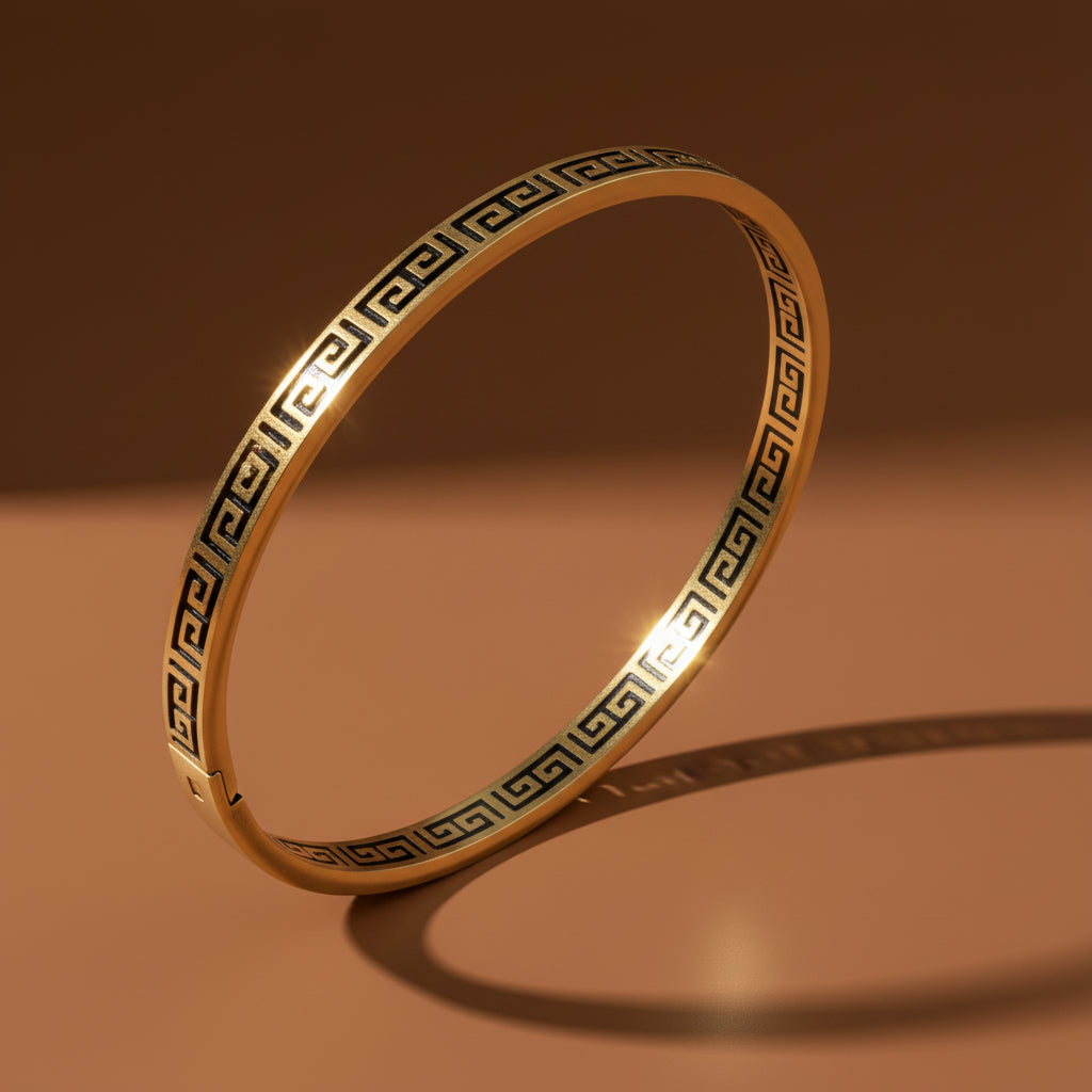 A high-resolution view of the Regal Key Bangle highlighting the detailed key motif and high-shine gold finish.