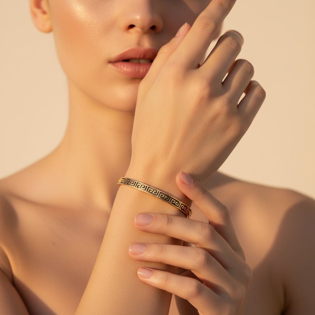 Gold bracelet with a pattern on a white textured surface