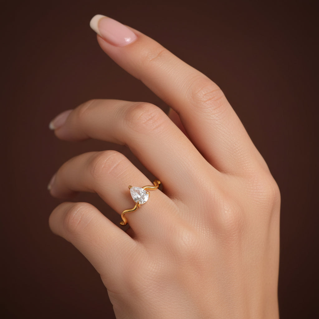 Female model wearing the Serena Wave Pear Ring with focus on the elegant pear-cut stone.