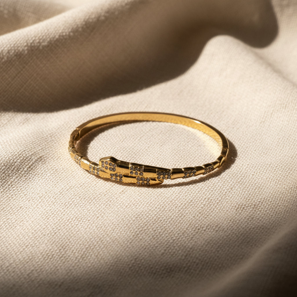 Gold bracelet with small stones on a textured gray surface
