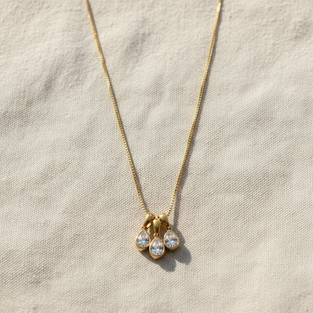 Trio Drop Charm Necklace worn around neck – delicate gold triple charm necklace for women