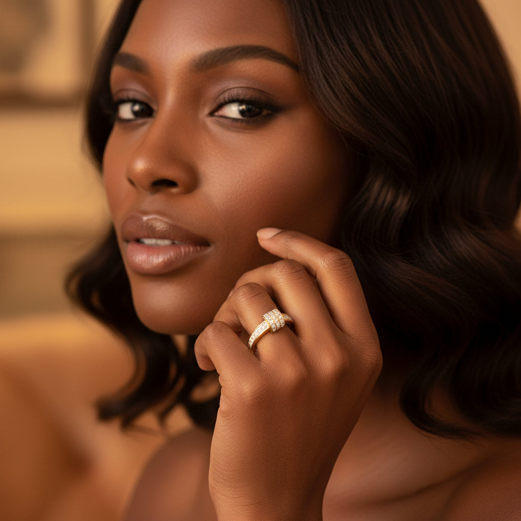 A stunning high-end e-commerce editorial photograph of a beautiful Black model under warm golden lighting, with her face visible and the focus zoomed in tightly on the gold white enamel crystal knot ring.