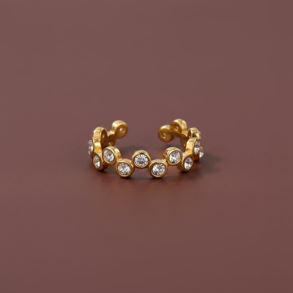 Professional catalogue flat lay of the gold plated zig zag wavy diamond eternity ring with soft shadows on a rich brown background.